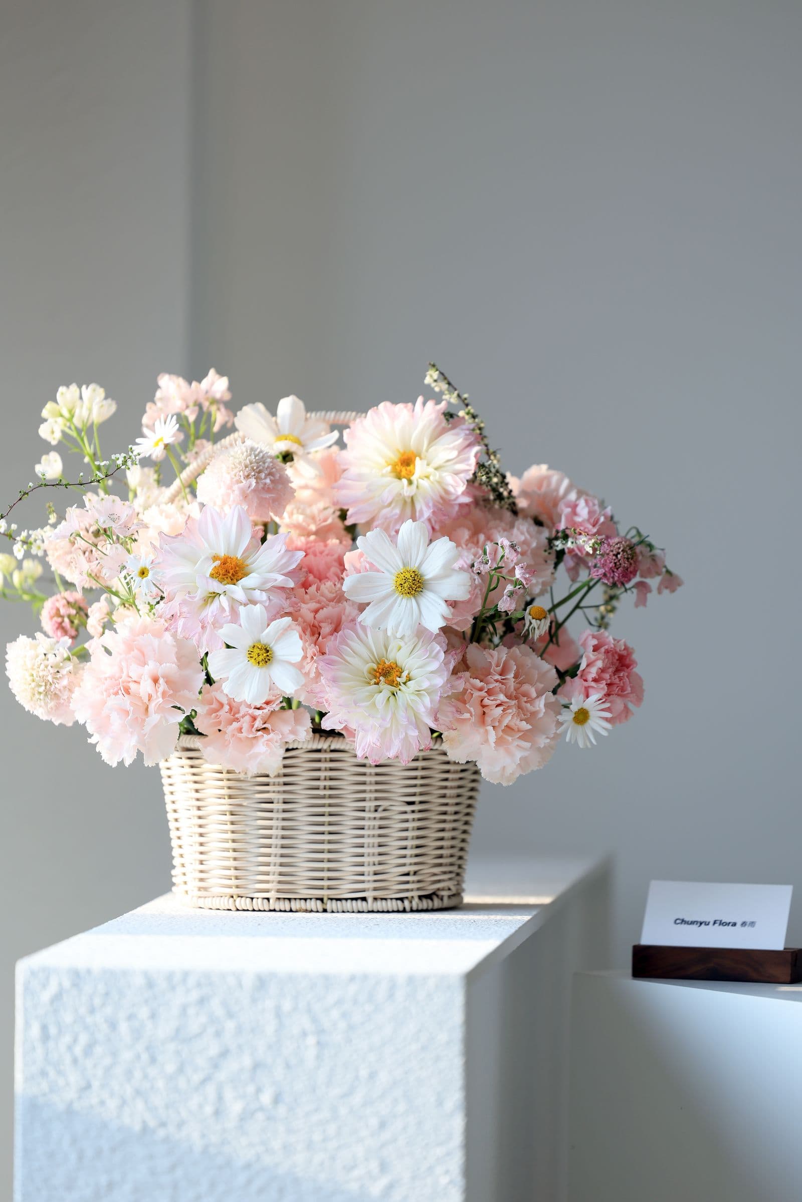 An elegant pastel flower arrangement in a woven basket
