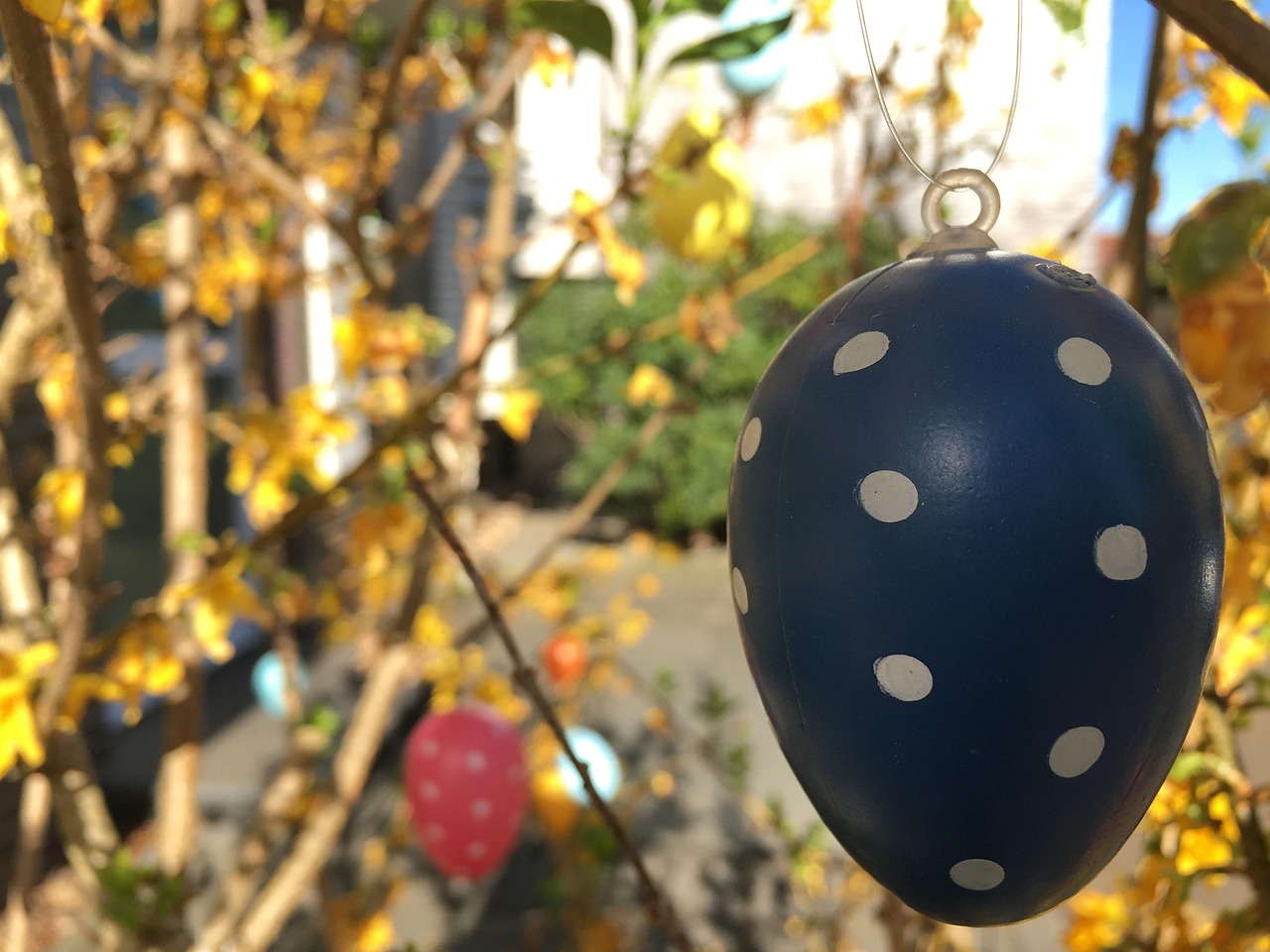 Hand-painted Easter eggs hanging from tree branches, an easy Easter egg tree craft